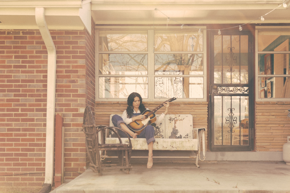 Lauren playing guitar sitting on the porch