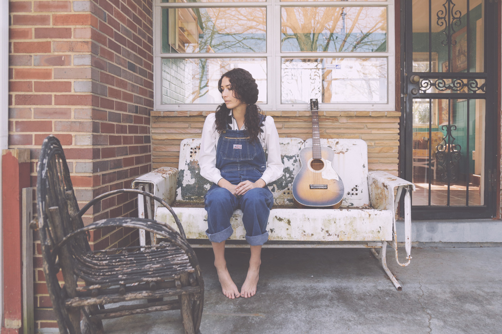 Lauren sitting on the porch with her guitar